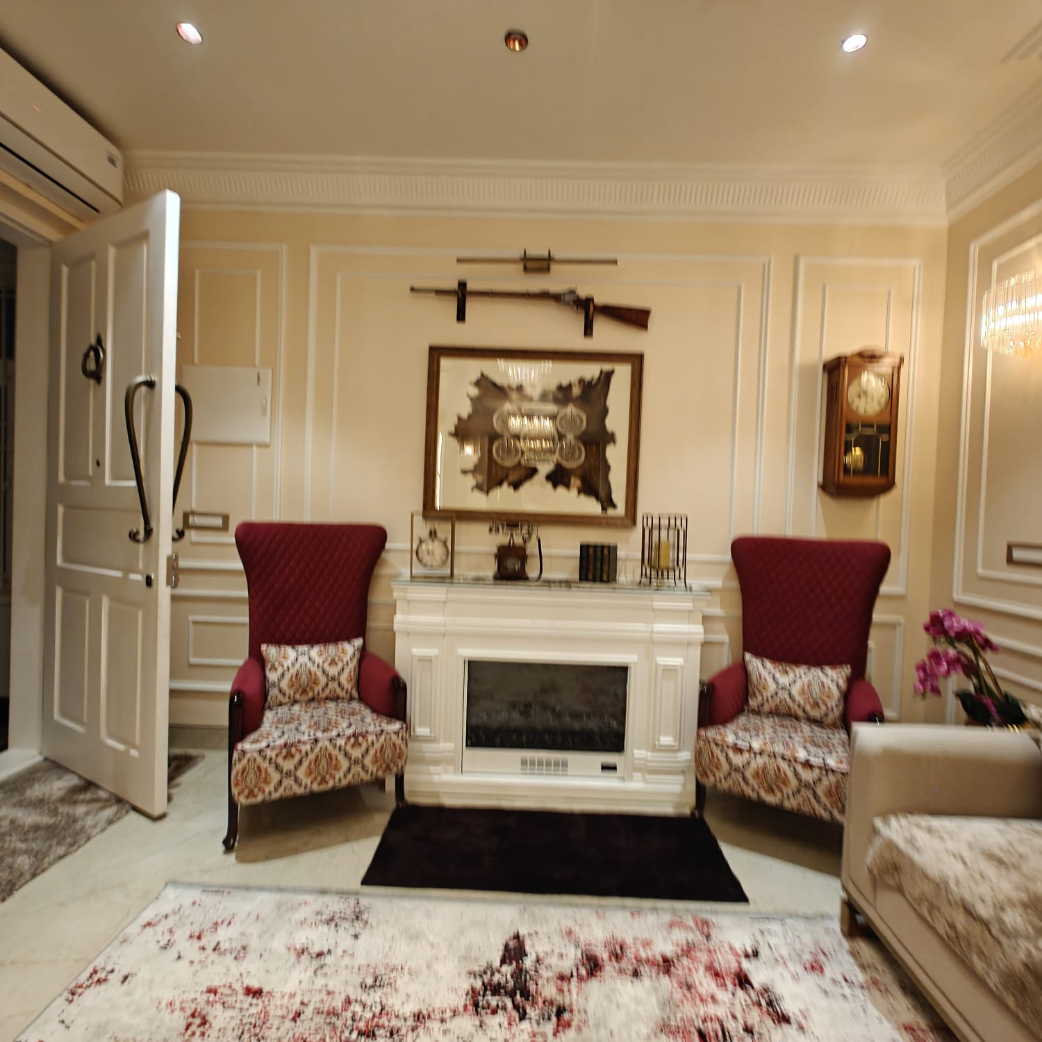 Fireplace sitting area with wainscoted walls — INKA